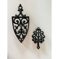 two black metal wall hangings on a white wall