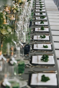 a long table is set with place settings and candles