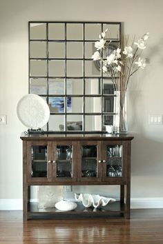 the pottery barn's elegant mirror is displayed in front of a vase with flowers