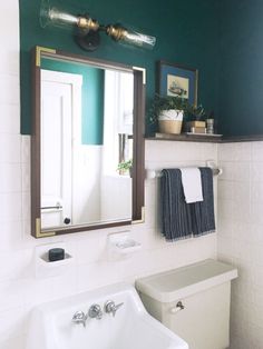 a white sink sitting under a bathroom mirror