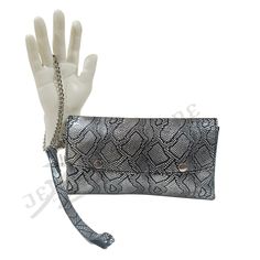 Rock this stylish, open all, 100% handmade fold-over wristlet/clutch with any outfit of your choice. This is crafted from shiny and reflective metallic reptile print cowhide leather. It features 2 detachable wrist straps(leather strap and a chain strap) with silver-tone hardware. Can be carried as a clutch without the strap. * Wristlet/clutch * Metallic color * Size(s): 9.25"W × 4.5"H × 0.75"D (Small) 11"W × 5.25"H × 1"D (Large) * Button style/open style * Snap closure * Silver-tone hardware * G Trendy Rectangular Clutch With Wrist Strap, Evening Clutch With Wrist Strap, Chic Silver Clutch For Everyday Use, Trendy Silver Clutch For Formal Occasions, Trendy Wristlet Clutch With Wrist Strap, Modern Clutch With Wrist Strap, Trendy Clutch With Wrist Strap, Party Wristlet With Wrist Strap, Trendy Silver Rectangular Clutch