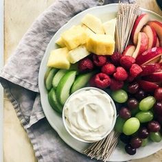 a white plate topped with fruit and dip