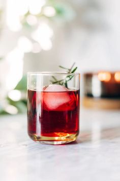 a glass filled with red liquid sitting on top of a table