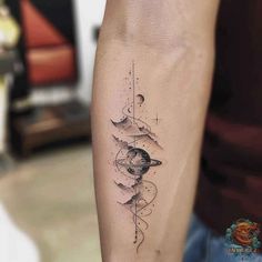 a person with a tattoo on their arm that has an image of the moon and stars