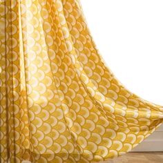 a yellow and white curtain with circles on it in front of a window sill