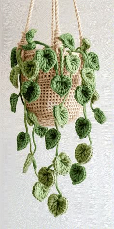 a crocheted bag with green leaves hanging from it