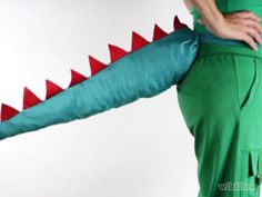 a person in green pants with a red and white dragon costume on their back legs