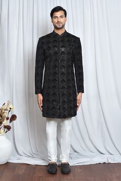 Black velvet sherwani with mandarin collar, all over checkered pattern, tonal sequin and cut dana embroidery. Paired with white churidar.
Components: 2
Pattern: Embroidered
Type Of Work: Cut Dana and Sequin Work
Neckline: Mandarin Collar
Sleeve Type: Full Sleeves
Fabric: Sherwani: Velvet, Churidar: Poly Viscose
Color: Black
Other Details: 
Closure:
Sherwani: Front concealed placket
Churidar: Front drawstrings and concealed zip
Note: The pocket square worn by the model is not for sale
Occasion: C Velvet Churidar, Velvet Sherwani, Black Sherwani, White Churidar, Churidar, Full Sleeves, Checkered Pattern, Mandarin Collar, Pocket Square