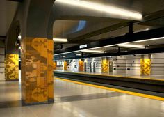 an empty subway station with yellow and white walls