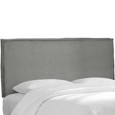 an upholstered headboard with white sheets and pillows