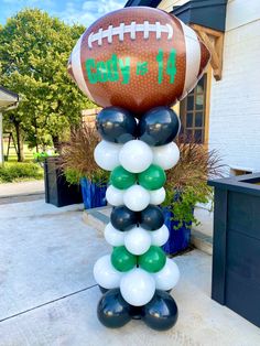 a football balloon tower is decorated with balloons and the number four on it's side