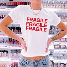 Indulge in the nostalgic appeal of our Fragile Baby Tee, a garment that echoes the iconic 90's fashion combined with a witty humor twist. Expertly crafted for those who appreciate a light, airy fit and a timeless design, this tee is an essential addition to any fashion-forward collection. The model is wearing an XS size. Our size guide ensures a perfect fit. Witty Humor, 90's Fashion, Funny Baby, Revlon, Baby Tee, Infant Tees, 90s Fashion, Timeless Design, Size Guide