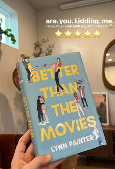 a person holding up a book in front of a mirror with the words better than the movies written on it