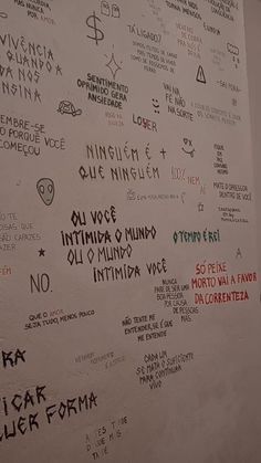 a white wall covered in lots of different types of writing on it's side