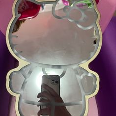 a person taking a photo of their hello kitty mirror