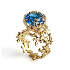 This coral ring in yellow gold with a large top quality Blue Topaz is part of a collection inspired by the living sculptures of corals. Blue Topaz gemstones promote harmony and relaxation. Often associated with loyalty and love, this gem represents eternal romance and friendship, which makes it a perfect choice for your engagement ring. All our jewels are original creations designed in our studio, available exclusively at our online shops. They are skilfully handcrafted per order with constant a Blue Topaz Ring Gold, Gold Topaz Ring, Unique Gold Rings, Blue Topaz Engagement Ring, Topaz Engagement Ring, London Blue Topaz Ring, Gold Statement Ring, Coral Ring, Gold Gemstone Ring