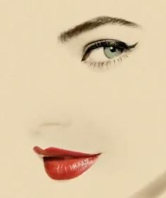 a woman's face with long eyelashes and red lipstick