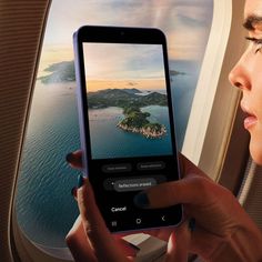 a woman looking at her cell phone while flying in an airplane with the window open