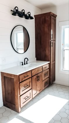 a bathroom with a sink, mirror and wooden cabinet in the corner on the wall