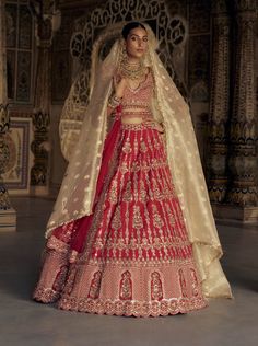 A captivating blood-red raw silk lehenga with a net dupatta, featuring gold kasab embroidery and delicate resham French knots, patras, dabka, beads, and sequins. It comes with a gold tissue stripe booti dupatta and embellished belt. Kasab Embroidery, Red Silk Lehenga, Embroidered Bridal Lehenga, Silk Lehenga Choli, Raw Silk Lehenga, Patras, Bridal Lehenga Red, Embellished Belt, Red Lehenga