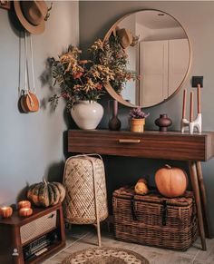 a room with a table, mirror and baskets on the floor