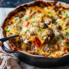 a casserole dish with meat, cheese and tomatoes