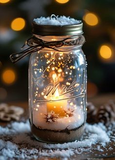 a mason jar filled with snow and a lit candle