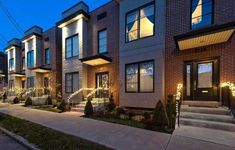 a row of townhouses at night with lights on the windows and steps leading up to them