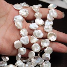 a person holding some pearls in their hand