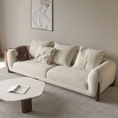 a white couch sitting in a living room next to a table