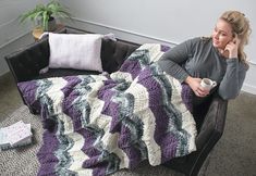 a woman sitting on a couch holding a coffee cup