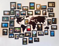 a world map made up of many different frames on the wall with people's pictures