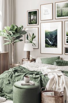 a bedroom with green bedding and pictures on the wall above it's bed