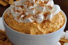 a white bowl filled with marshmallows on top of a table next to chips