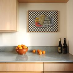 a bowl of oranges sitting on top of a kitchen counter