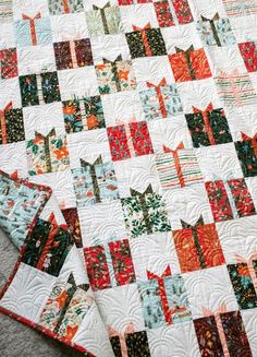 two quilts that are laying on the floor next to each other and one has an orange, green, red, and white design