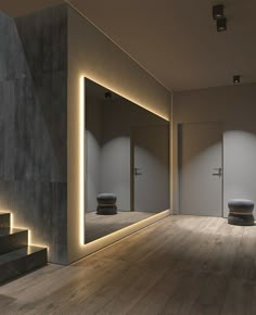 an empty room with some lights on the wall and stairs leading up to two doors