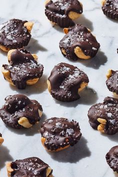 chocolate covered cookies with nuts and sea salt on a marble counter top, ready to be eaten