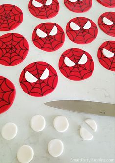 the spiderman cupcakes are decorated with white icing