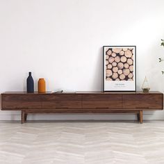 a wooden shelf sitting on top of a white tiled floor next to a vase filled with flowers