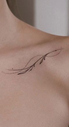 a woman's chest with an arrow tattoo on it