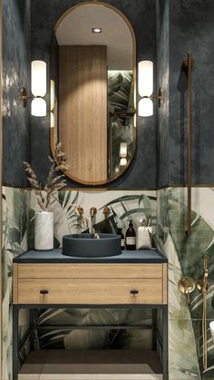 a bathroom with blue and green wallpaper, gold fixtures and a mirror above the sink