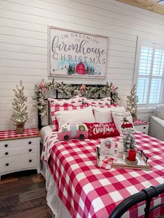 a bedroom decorated for christmas with red and white plaid bedding, pine tree garlands