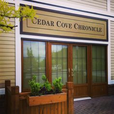 the front entrance to cedar cove chronice with potted plants on the outside window