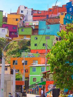 a city street with lots of colorful buildings on the hill in the backround