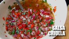 salsa criola in a white bowl with a spoon