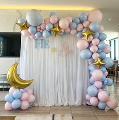 an arch made out of balloons with stars and moon on the top for a baby shower