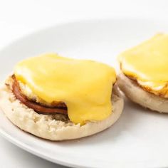 two english muffins covered in cheese on a white plate