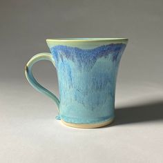 a blue and green cup sitting on top of a table