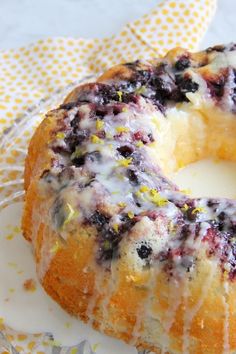 a blueberry bunt cake sitting on top of a white plate next to a yellow polka dot napkin